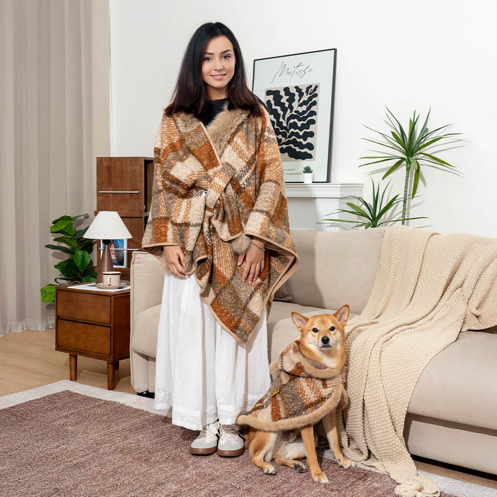 Owner sitting with dog, both bundled in matching red plaid ponchos, soft polar fleece.