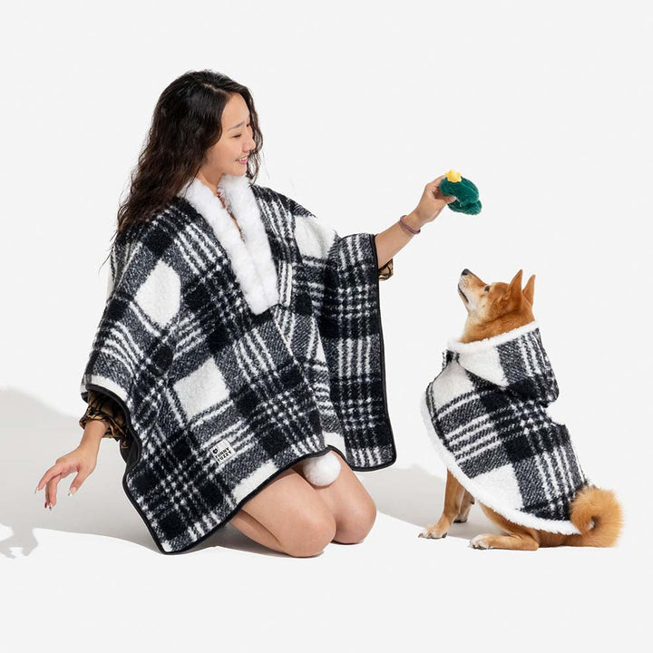 Owner and dog in matching plaid ponchos, front view, comfortable and warm dog apparel.