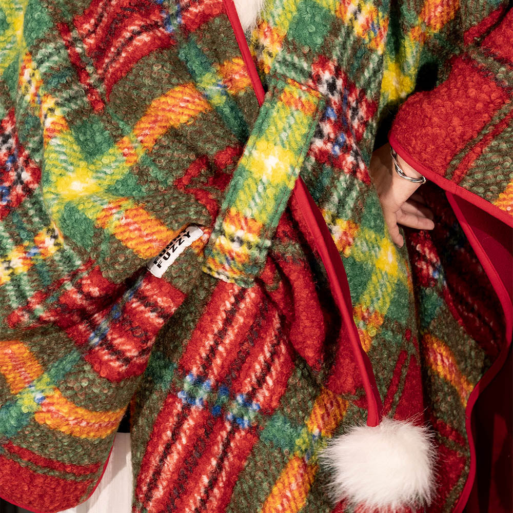 Side view of a dog wearing a red plaid poncho, showcasing the full coverage, warm pet clothes.