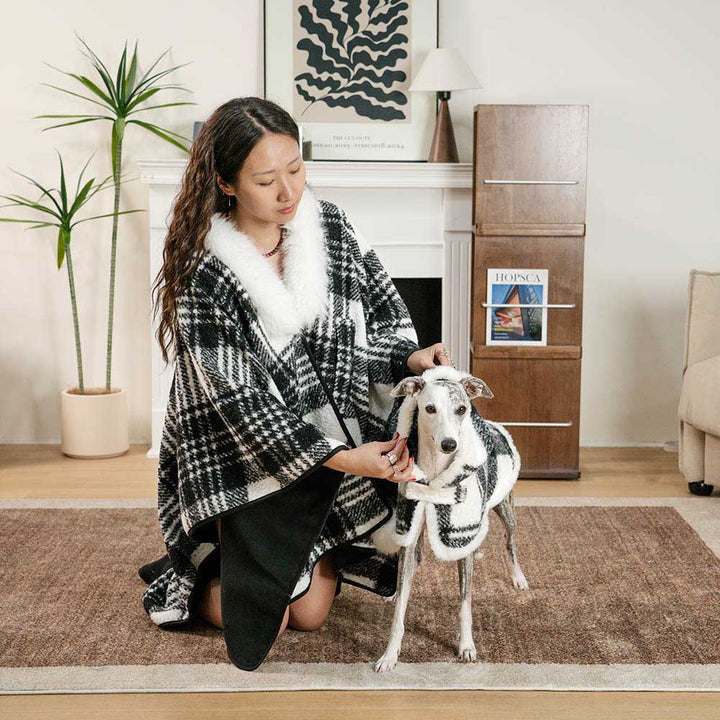 Close-up of dog wearing a red plaid poncho, soft polar fleece pet apparel for warmth.