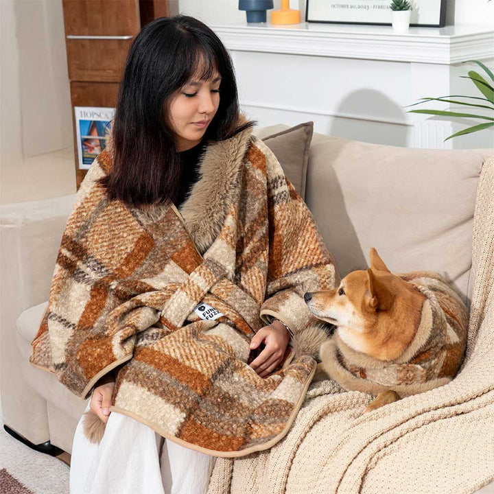 Happy owner with dog, both in matching plaid ponchos, holiday outfit dog apparel set.