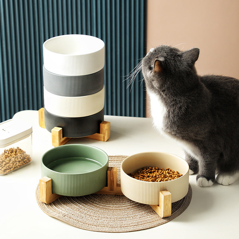 Matt green ceramic pet feeding bowls on a natural wooden stand, elevated for comfortable eating.