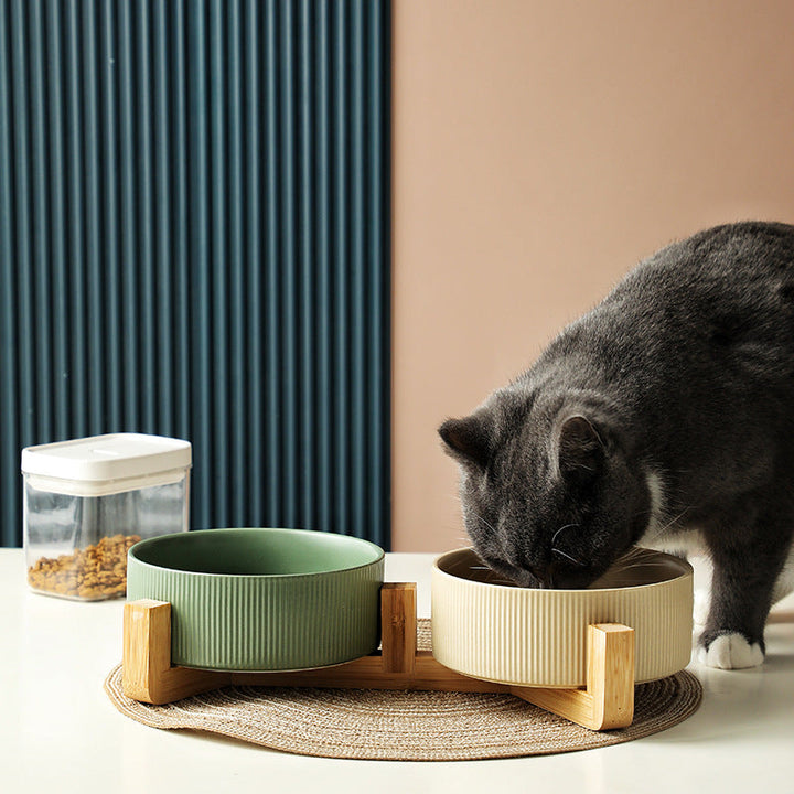 Modern pet feeding station featuring two matt black ceramic bowls in a stylish wooden frame.