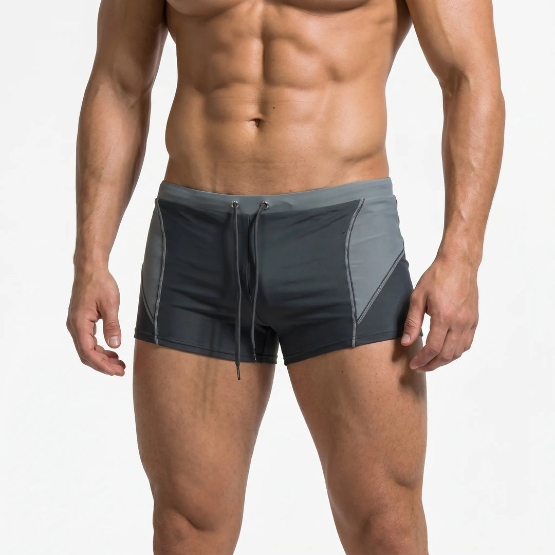 Stylish men's color-block boxer swim trunks, essential beachwear for active men & summer fashion.