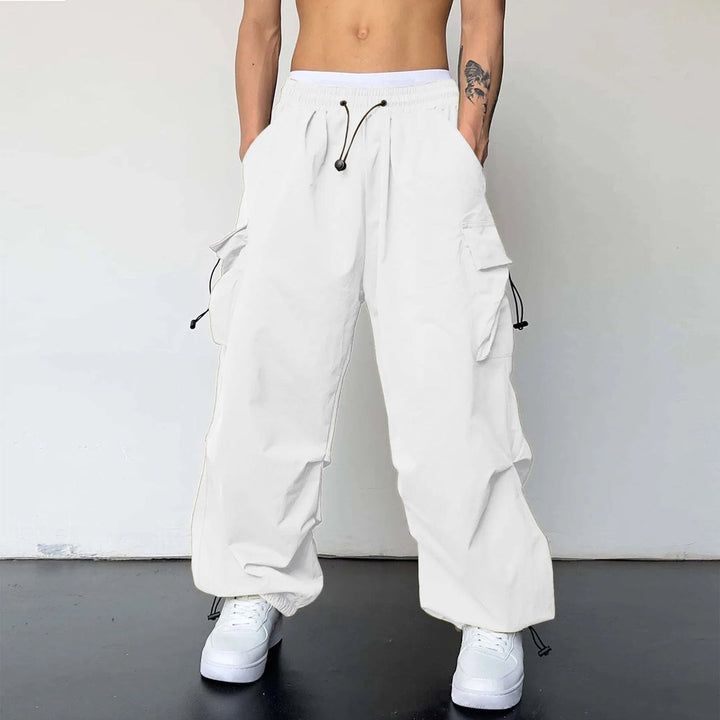 Men's baggy cargo parachute pants in Y2K streetwear style, featuring loose fit, multiple pockets, and elastic waist.