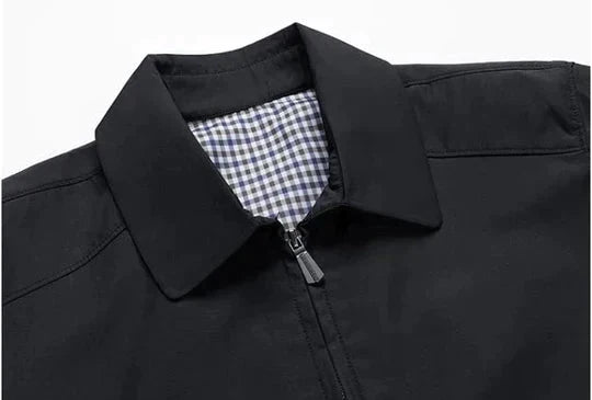 Close-up of the men's black zip-up jacket, highlighting the quality fabric & patterned checked lining.