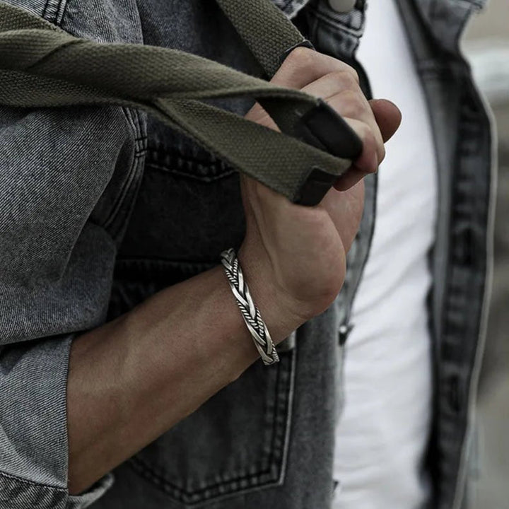 Close-up of a men's braided sterling silver cuff bracelet with intricate detail. A classic silver jewelry gift.