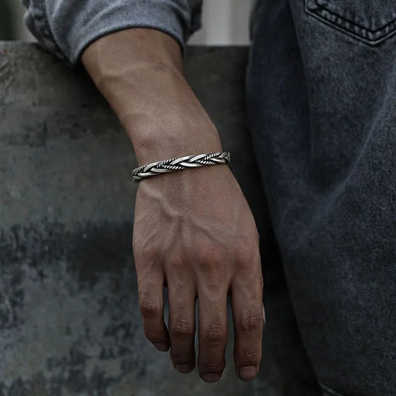 Men's sterling silver braided open cuff bracelet worn on a wrist, showcasing its adjustable & modern design.