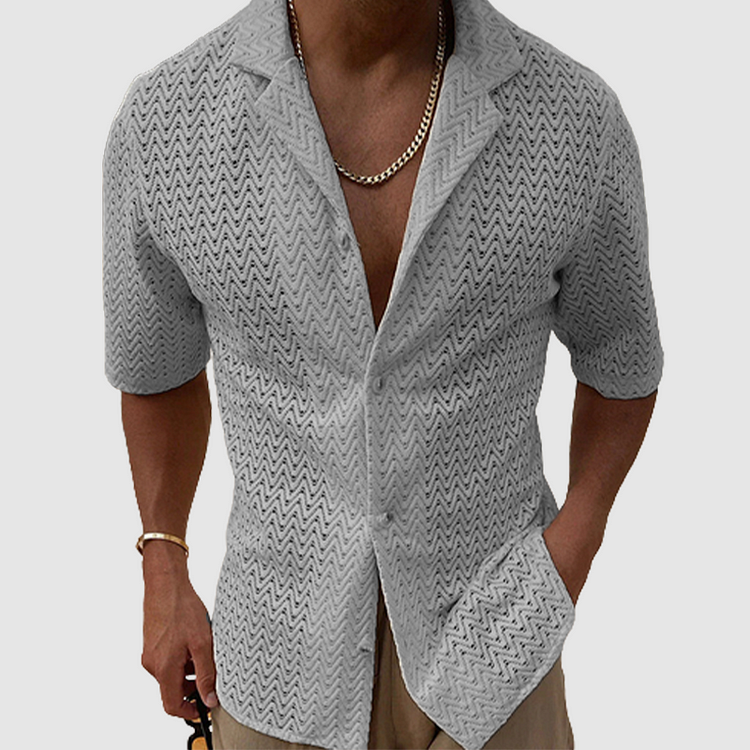 Comfortable men's open-weave leisure shirt, designed with breathable fabric for relaxed summer wear. Short sleeve fit.