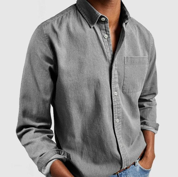 Back view of a men's classic long sleeve blue denim shirt, highlighting its timeless cut & versatile design.