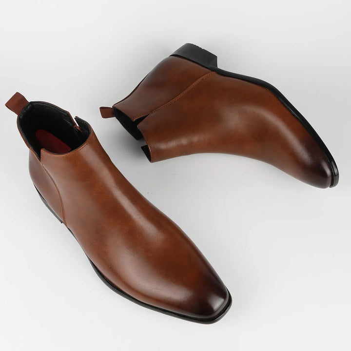 Stylish men's black leather slip-on Chelsea boots with a pointed toe, perfect for both dress and casual outfits.