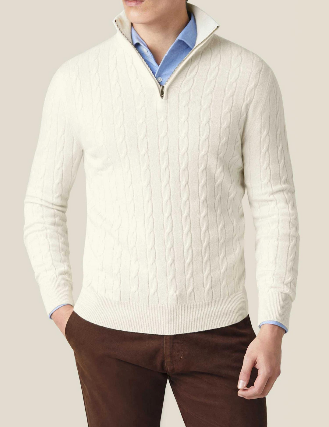 Close-up of the intricate cable-knit pattern on a men's quarter-zip sweater, showing texture.