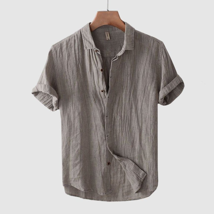Man wearing a stylish crinkle short sleeve shirt, showcasing its effortless fit and casual summer vibe.