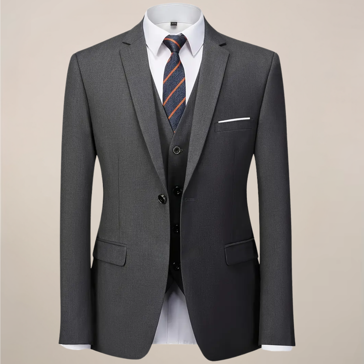 Stylish men's dark grey slim fit three-piece suit, featuring jacket, vest, and trousers for sophisticated event attire.