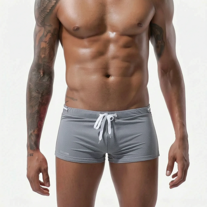 Dark blue men's fitted low-rise swim trunks, quick-drying & comfortable beachwear.