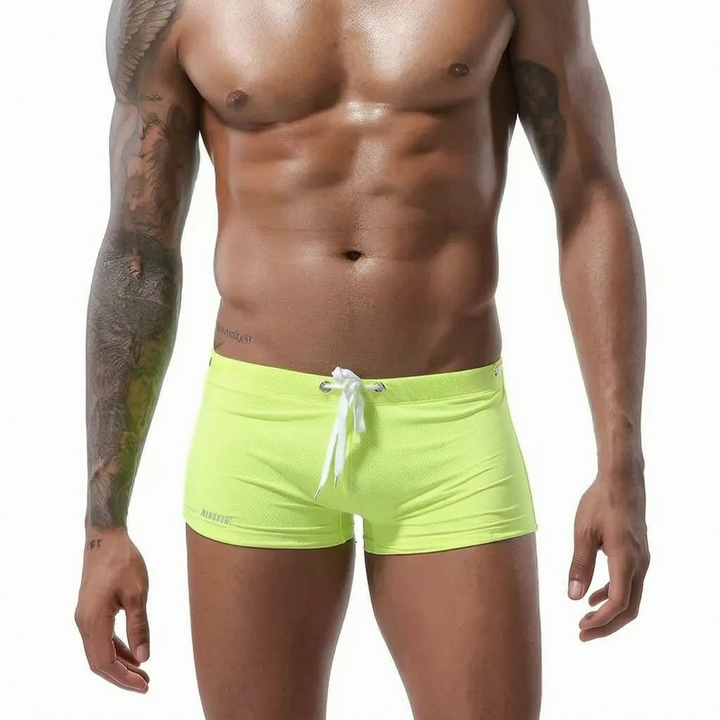 Black men's fitted low-rise boxer swim trunks, quick-drying for enhanced movement.