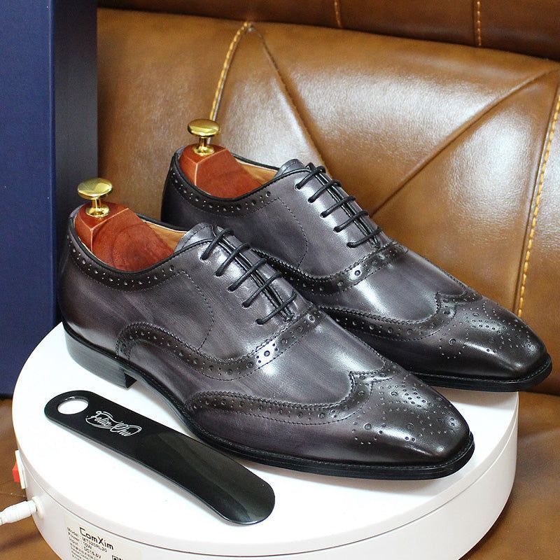 Elegant men's brown leather wingtip Oxford shoes with detailed brogue stitching, ideal for sophisticated dress.