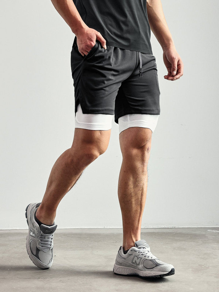 Male model showcasing Men's Kinetic Performance Active Shorts. Ideal for gym workouts & casual wear.