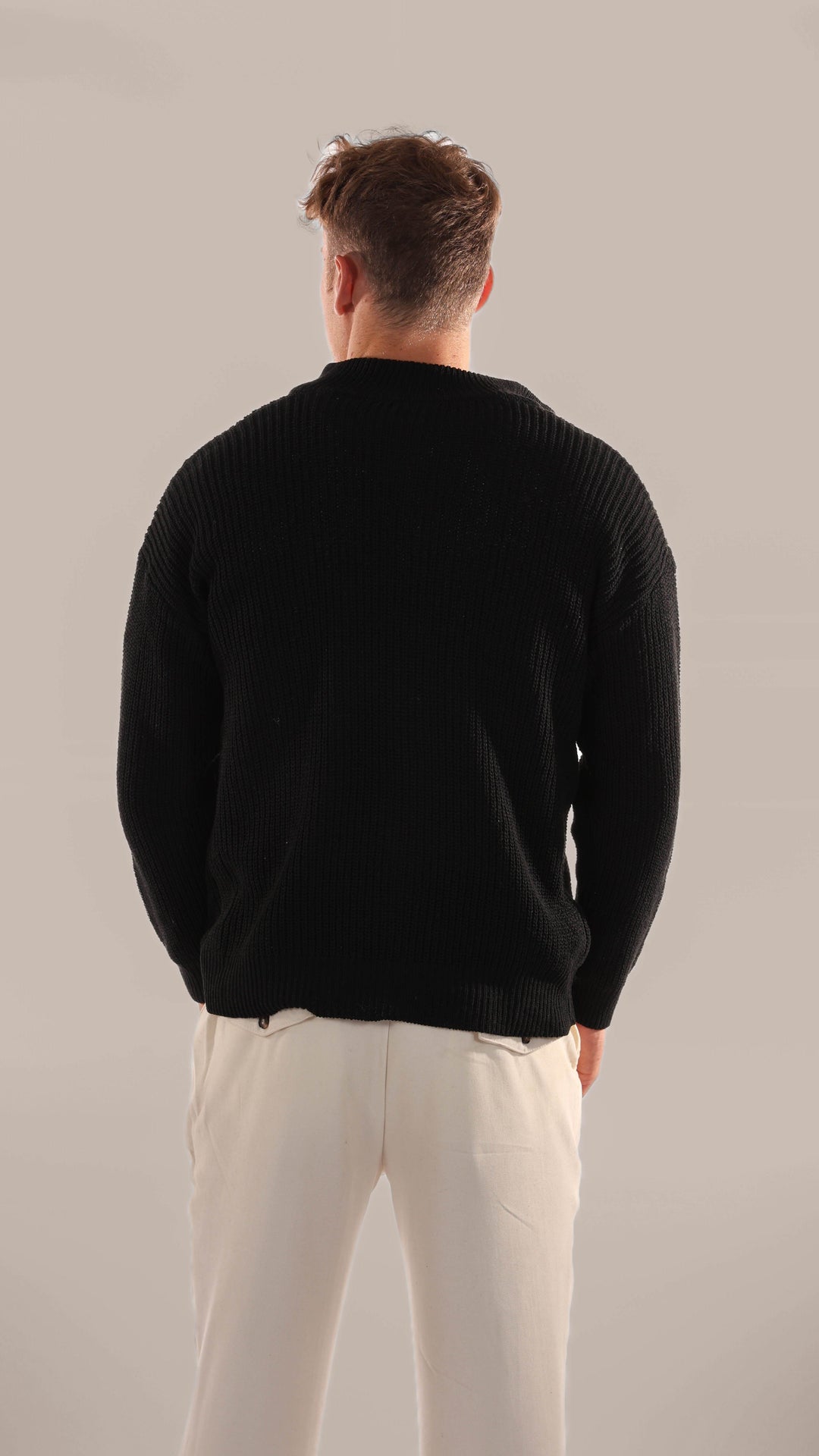 Close-up of a men's knitted half zip sweater, showcasing texture & long sleeves for winter layering.