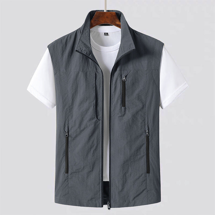 Close-up of men's lightweight zip vest showing practical utility pockets with secure closures, ideal for fall layering.
