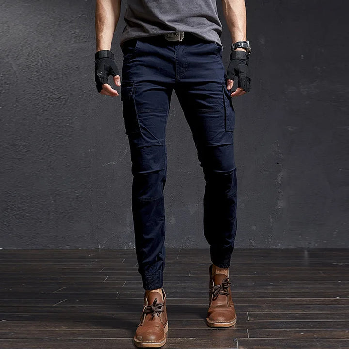 Stylish Outland men's cargo pants, utility pockets, tapered leg, cuffed ankle. Perfect for streetwear & action.