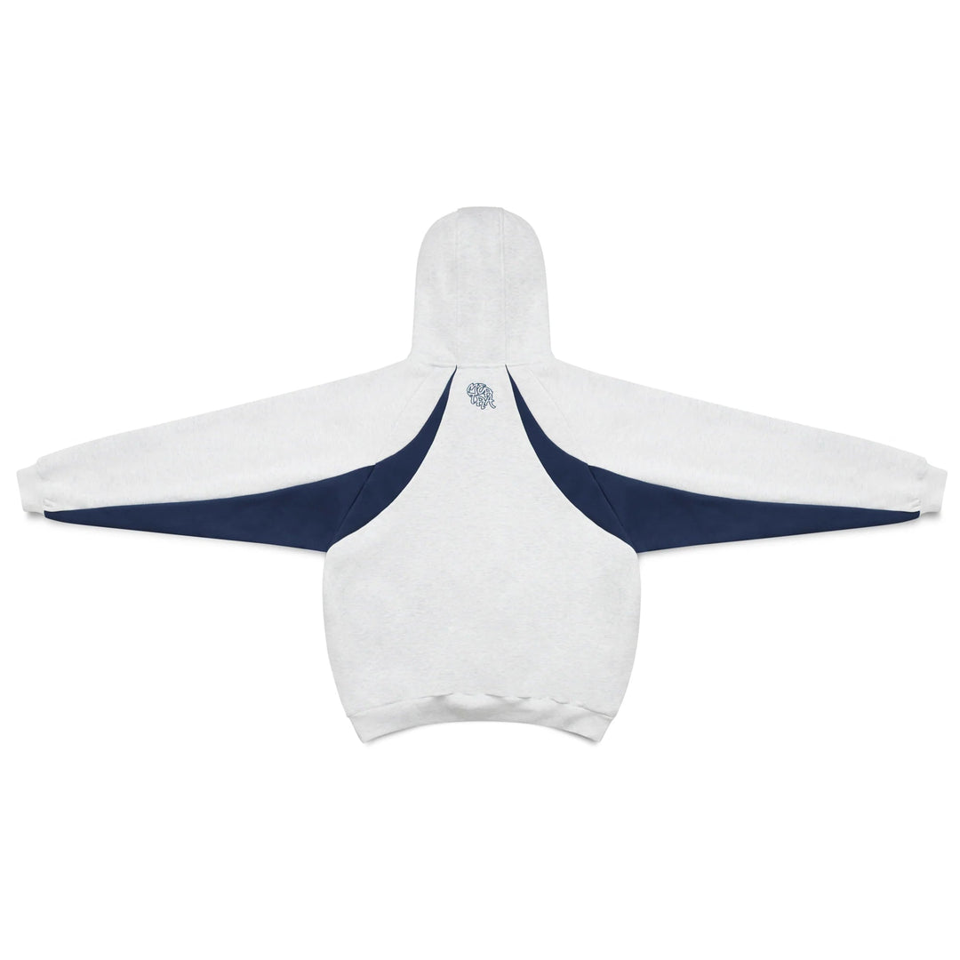 Man wearing oversized pullover hoodie with sporty contrast panels. Dynamic men's fashion, active streetwear style.