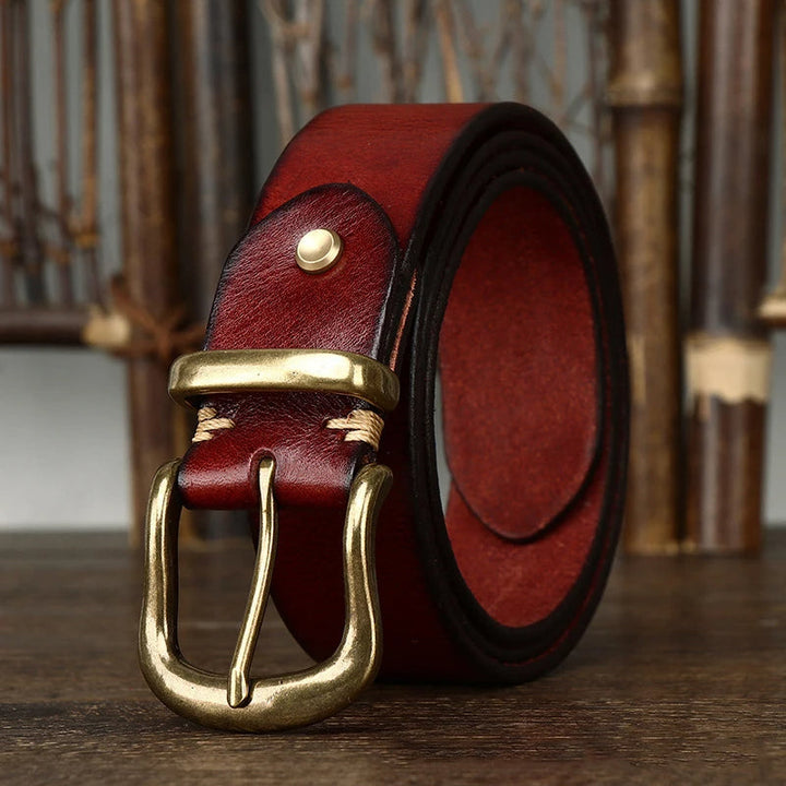 Man wearing a classic brown full-grain leather men's belt with blue jeans.