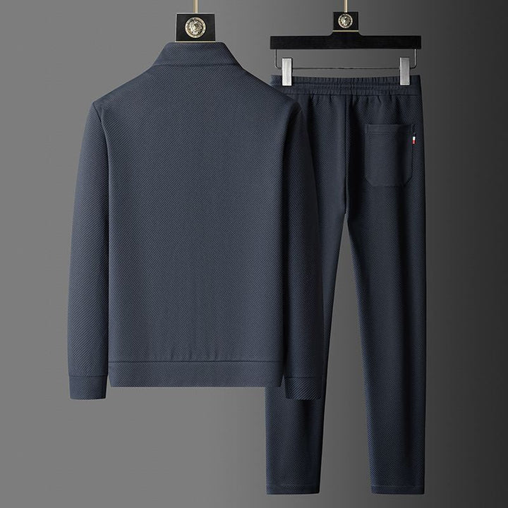 Close-up of men's zip-up tracksuit jacket, showcasing premium fabric and modern design for sporty look.