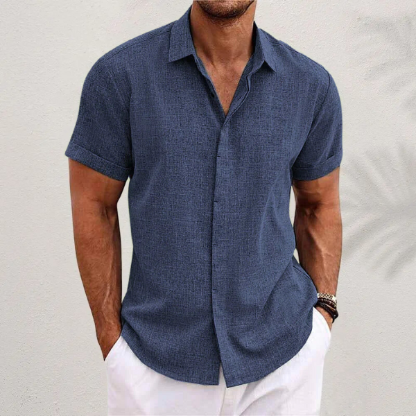 Man wearing a casual relaxed fit short sleeve button shirt with a classic collar, ideal for warm weather comfort.