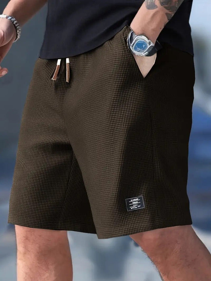 Side view of men's relaxed fit waffle knit shorts, highlighting pockets & comfortable elastic waist.