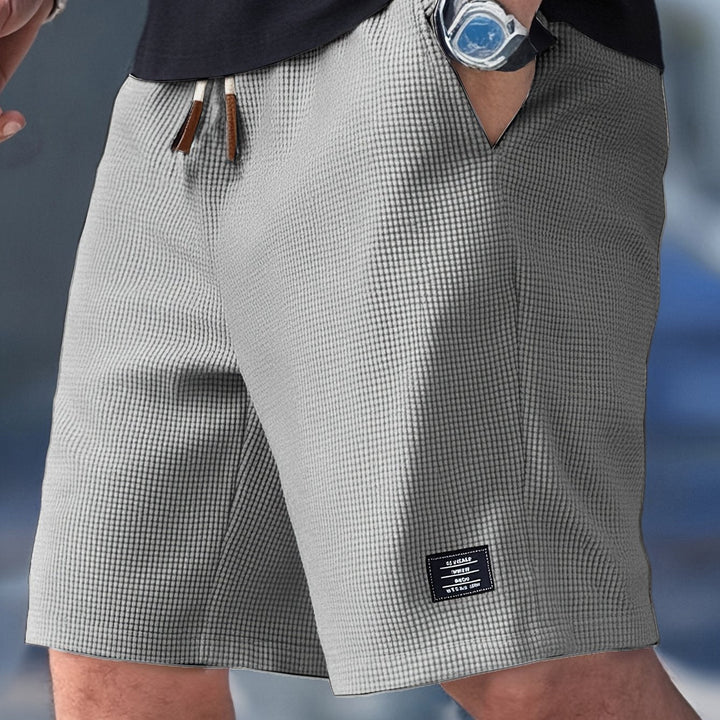 Man wearing relaxed fit waffle knit shorts, showing comfortable drape and casual summer style.