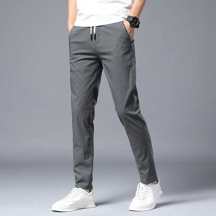 Man wearing dark slim fit comfort pants, showcasing tailored look & relaxed fit.