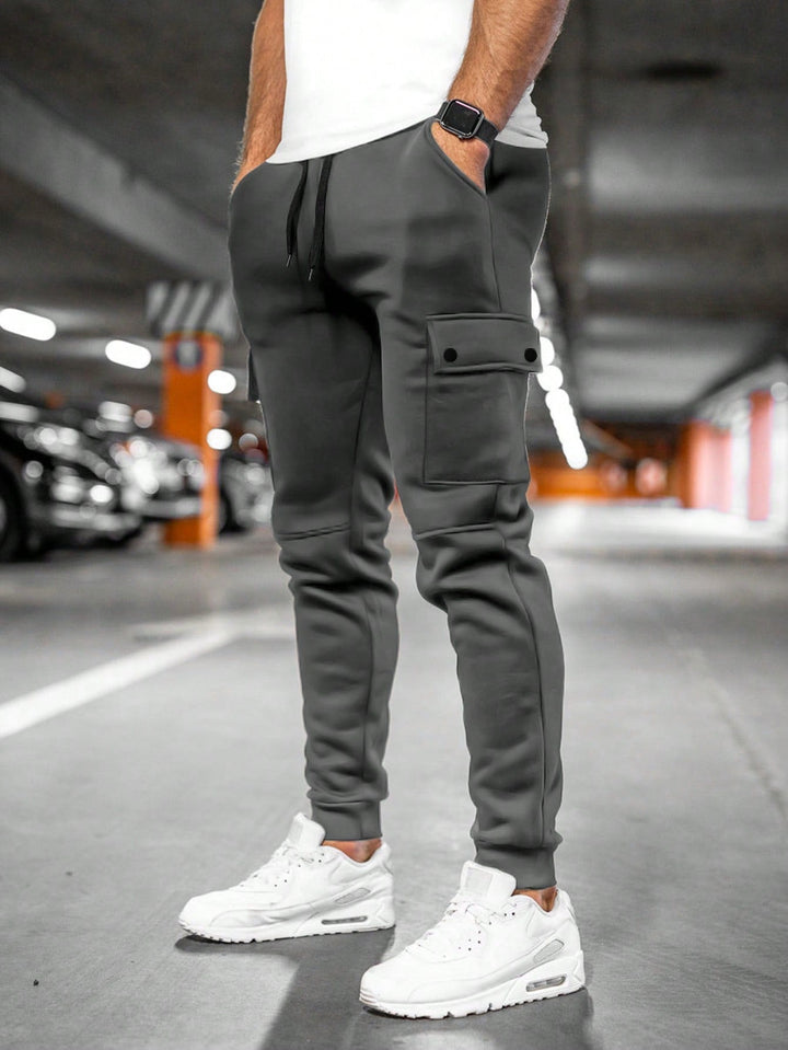 Men's slim-fit streetwear jogger pants with cargo pocket, tapered leg & ribbed cuffs, black.