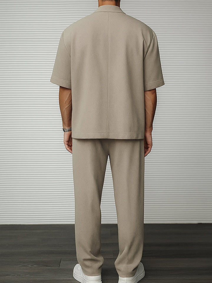 Tailored trousers matching a men's short sleeve blazer set, a sophisticated two-piece ensemble for any event.