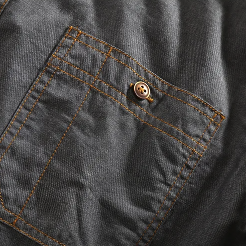 Close-up of a men's vintage urban button-up shirt, showing dual chest pockets and durable fabric texture.
