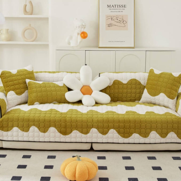 Comfortable sofa covered with a washable, non-slip milk velvet protector in a light cream color.