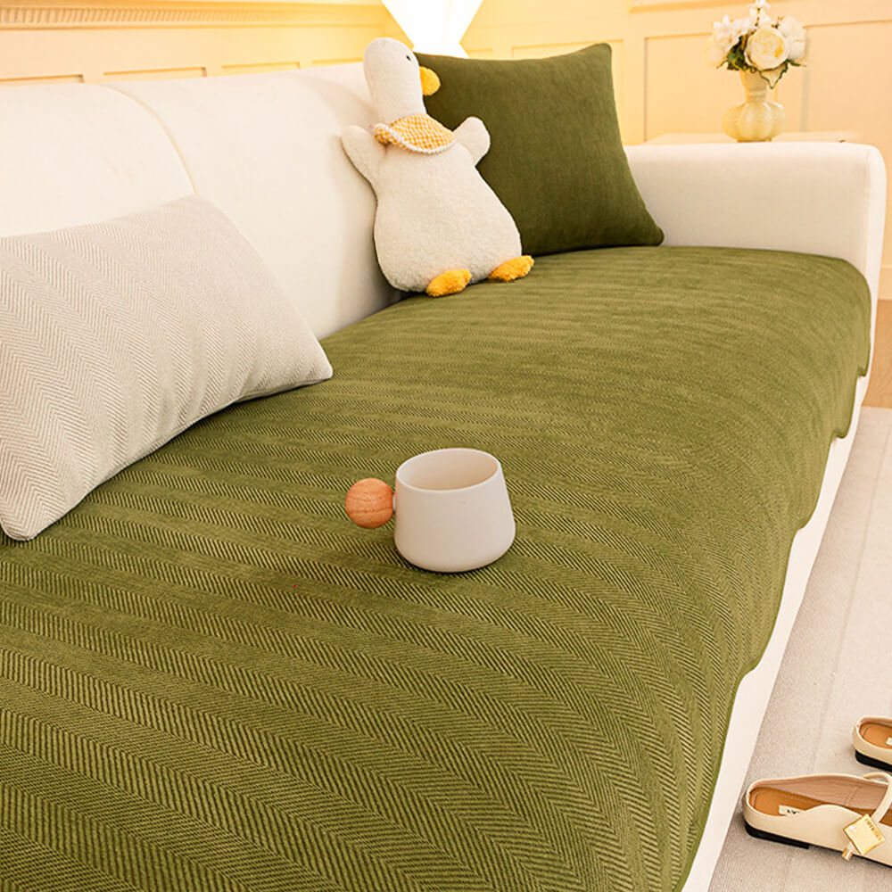 Non-slip backing visible on a minimalist herringbone chenille sofa protector, ensuring it stays in place.