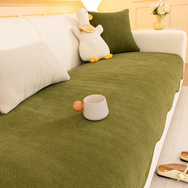 Non-slip backing visible on a minimalist herringbone chenille sofa protector, ensuring it stays in place.