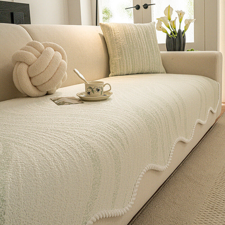 Corner of a sofa highlighting the braided edge of a white ice silk protector, comfortable and stylish