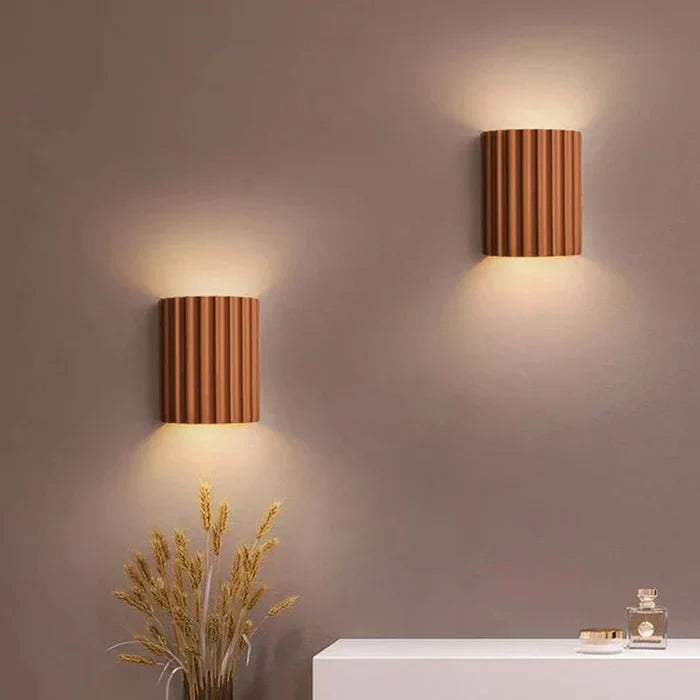 Contemporary resin wall sconce with integrated LED lighting for stylish interior decor.