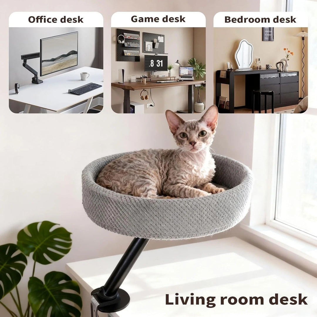 A cat napping peacefully in a beige desk-mounted cat bed, integrating pets into the workspace.