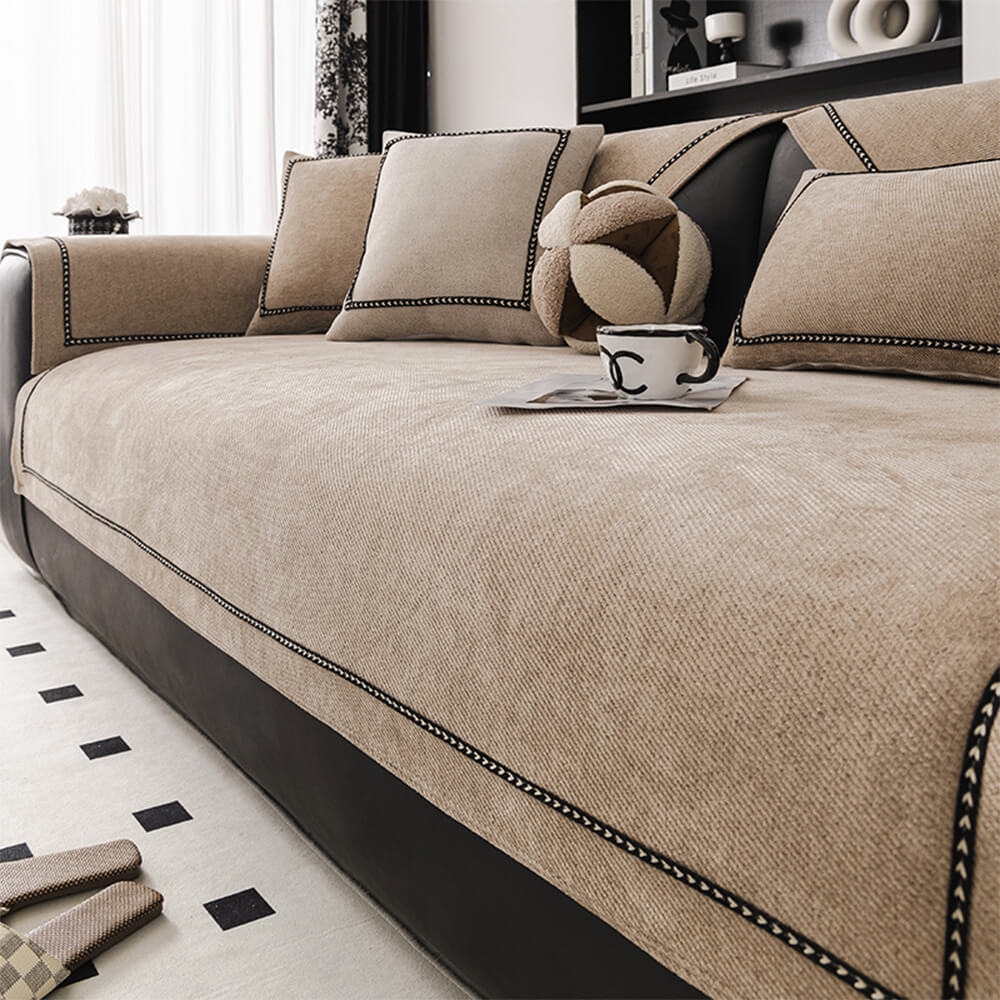 Close-up of modern jacquard pattern on a beige chenille couch cover, highlighting the textured fabric detail