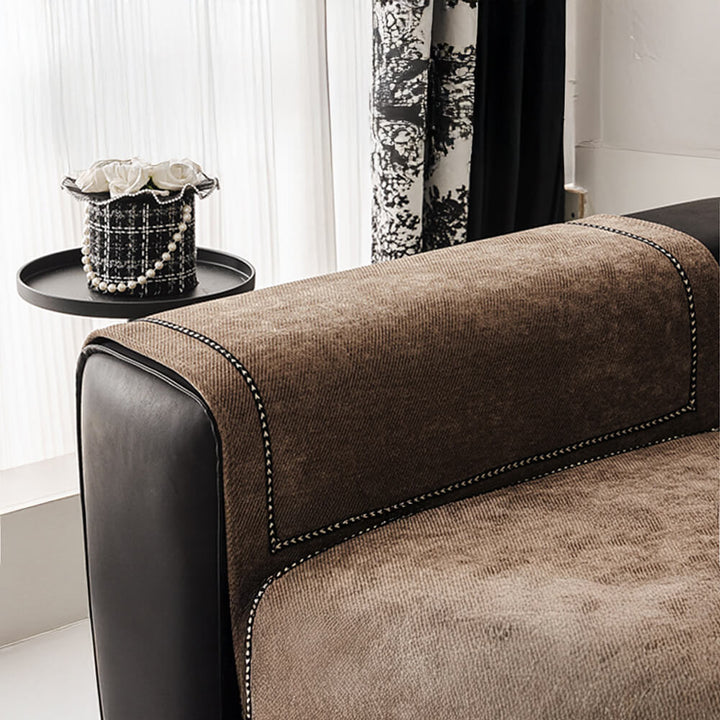 Detail of the non-slip grip on the underside of a modern jacquard chenille sofa slipcover, ensuring stability