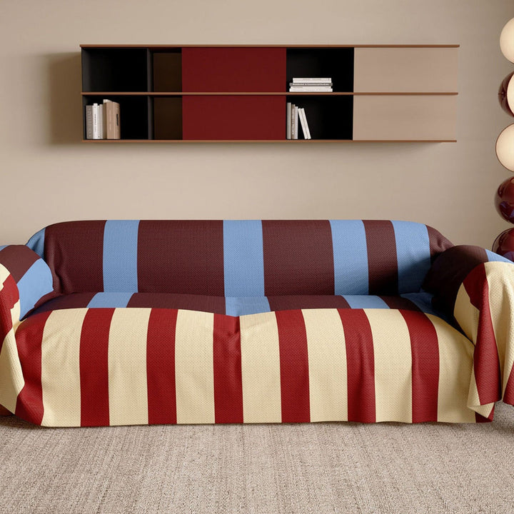 Modern striped sofa cover on a three-seater couch, protecting furniture with geometric pattern.