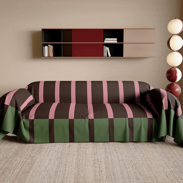 Full view of a living room with a sofa covered by a modern striped furniture protector.