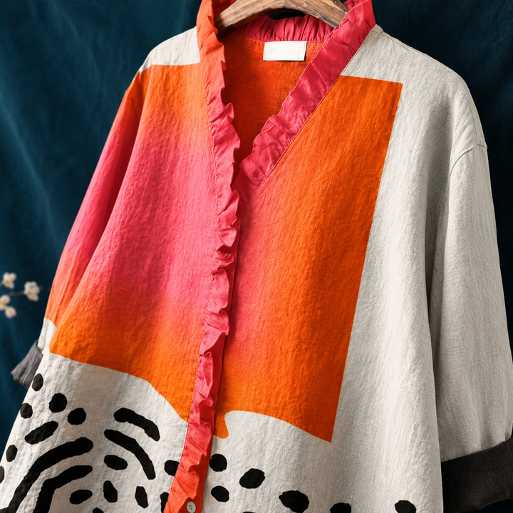 Stylish women's long-sleeve casual top featuring an abstract multicolor print and ruffled neckline, comfort wear.