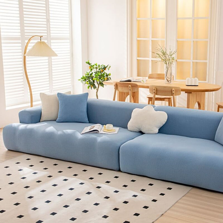 Navy blue stretchy waterproof couch cover protecting a three-seater sofa, pet friendly home decor
