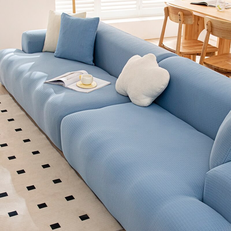 Installation process of a stretch sofa cover, showing its ease of application and snug fit