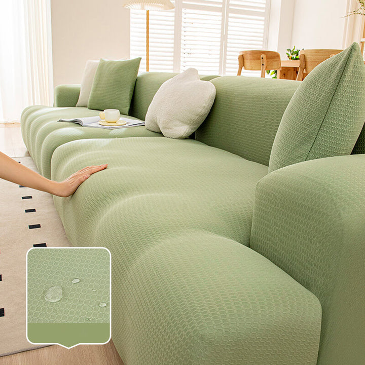 Child playing near a green anti-scratch sofa protector, emphasizing family-friendly furniture