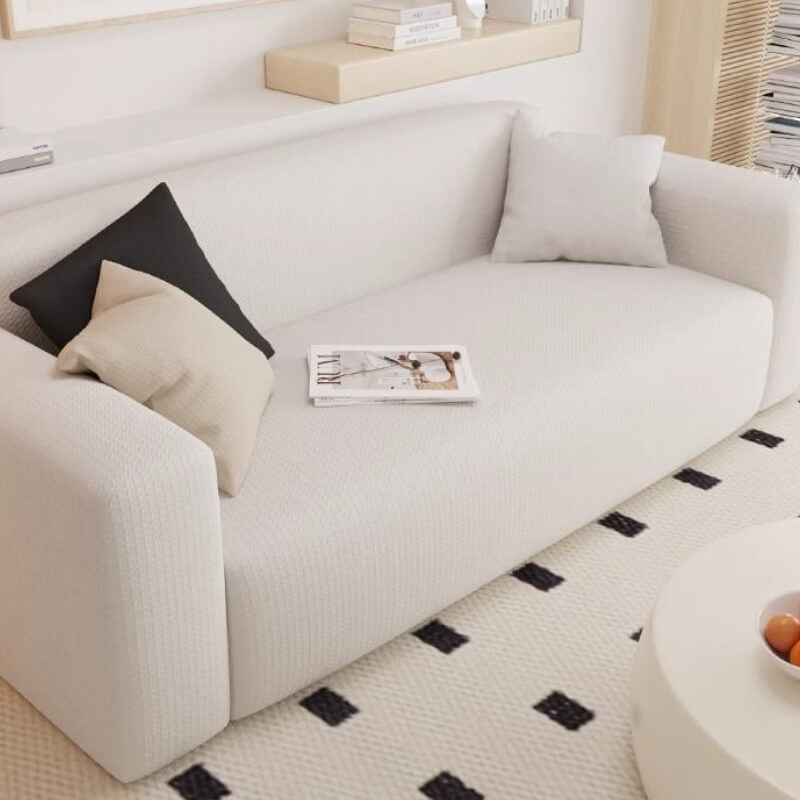 Living room scene with a neatly fitted beige stretchy sofa cover, enhancing home decor